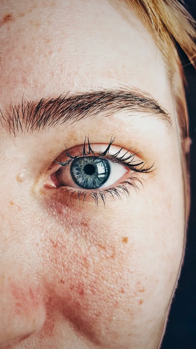 close up of a blue eye, textured iris, natural brow, real skin details