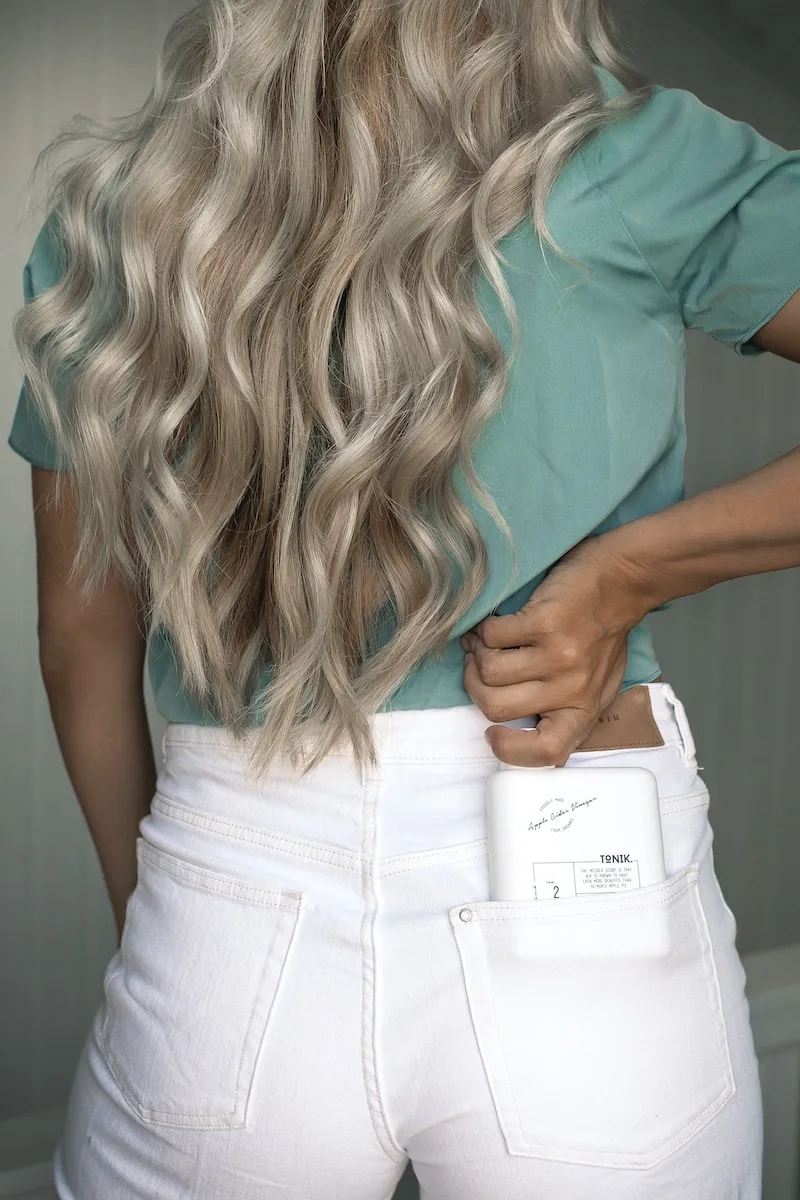 wavy silver blonde hair teal top white jeans